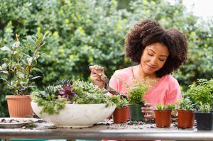 Black woman gardening at table outdoors