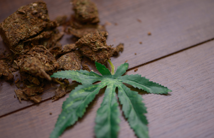 Marijuana, cannabis and cannabis leaf on wooden table.