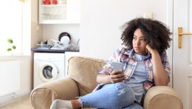 Young woman sitting at home and using smart phone
