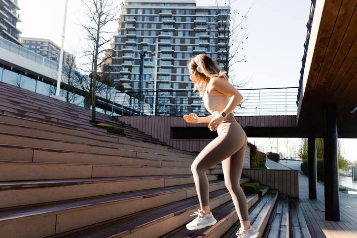 Young woman running up the stairs outdoors