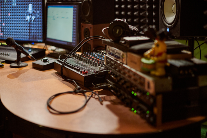 Professional audio mixing console and microphone in modern recording studio environment