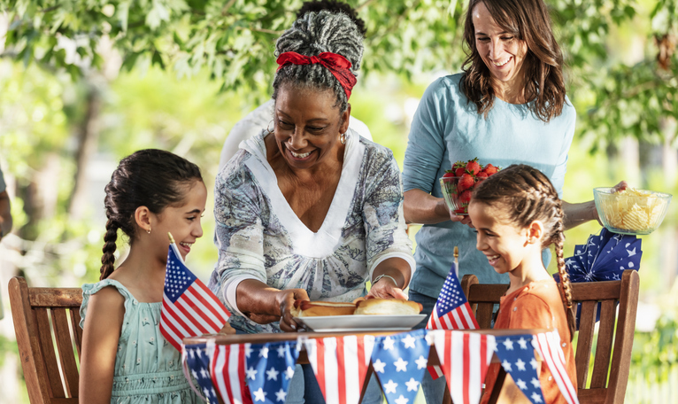 Grandmother, mom, serve girls hot dogs on Fourth of July