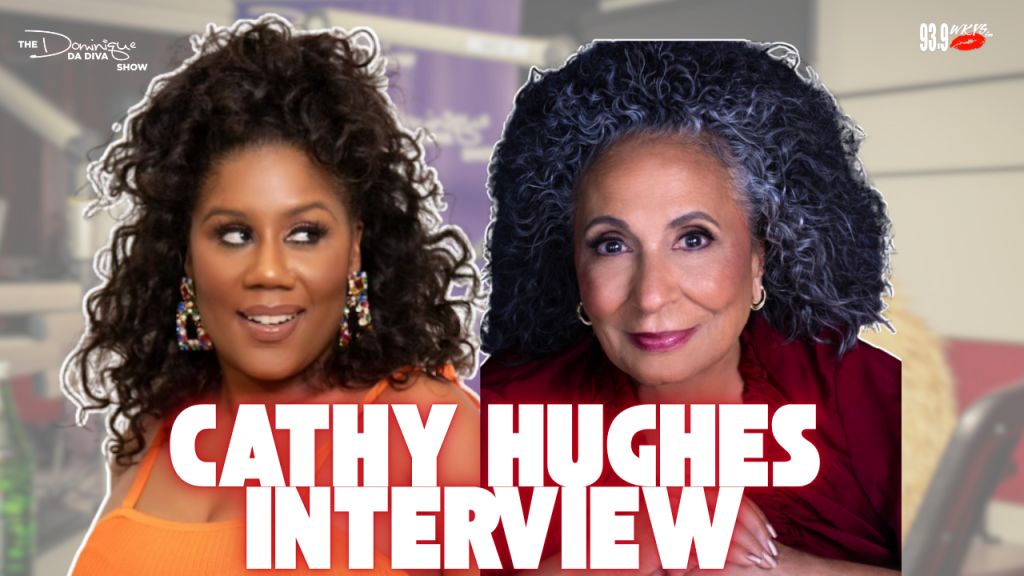 Two women with curly dark hair, one wearing an orange top and the other a red jacket, being interviewed on a television set with a 93.9 logo visible.